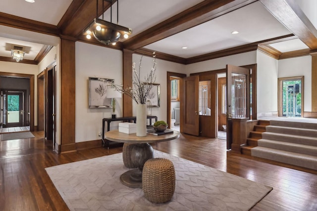 entrance foyer with a wealth of natural light, ornamental molding, and dark hardwood / wood-style floors