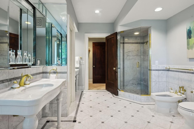 bathroom featuring toilet, a shower with shower door, a bidet, sink, and tile walls