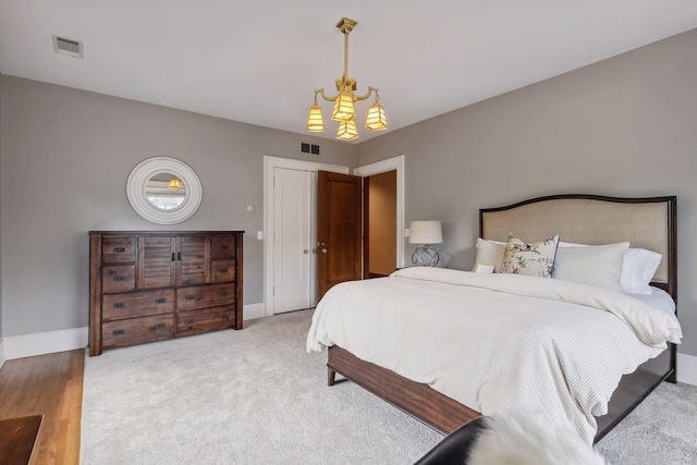 bedroom with light wood-type flooring and an inviting chandelier