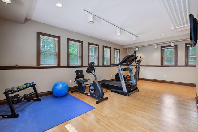 exercise room featuring track lighting and light wood-type flooring