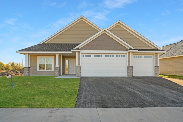 craftsman inspired home featuring a front yard and a garage