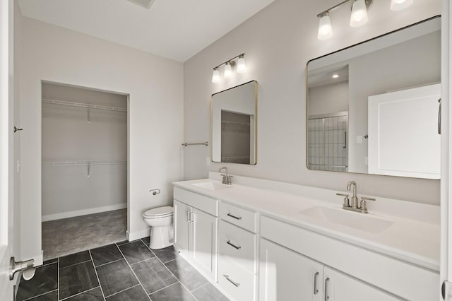 bathroom with toilet, vanity, and tile patterned flooring