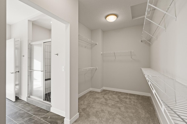 walk in closet featuring dark colored carpet