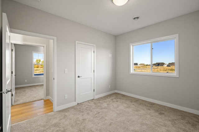 unfurnished bedroom with multiple windows and light colored carpet