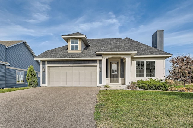 view of front of property featuring a front lawn and a garage