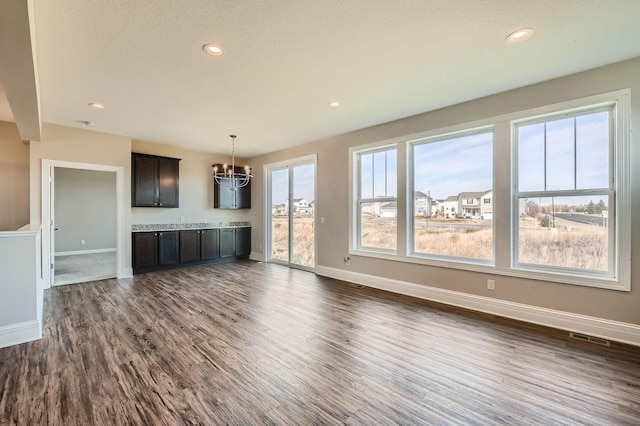 2711 Buffalo Ridge Dr, Buffalo, MN 55313 - unfurnished living room with an inviting chandelier, visible vents, dark wood-style flooring, baseboards, and recessed lighting