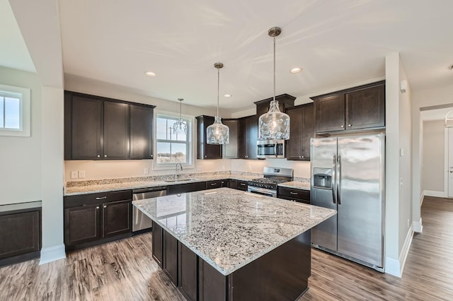 2711 Buffalo Ridge Dr, Buffalo, MN 55313 - kitchen featuring a center island, dark brown cabinets, a sink, stainless steel appliances, and light stone countertops
