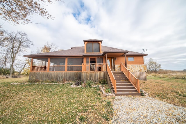 view of front of property featuring a sunroom and a front lawn