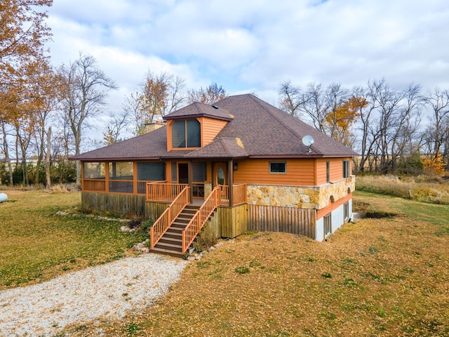 view of front of property featuring a sunroom and a front yard