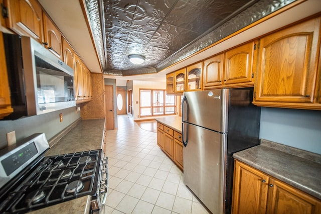 kitchen featuring light tile patterned flooring, a raised ceiling, and stainless steel appliances