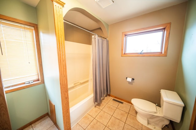 bathroom with tile patterned floors, toilet, and shower / bath combo with shower curtain