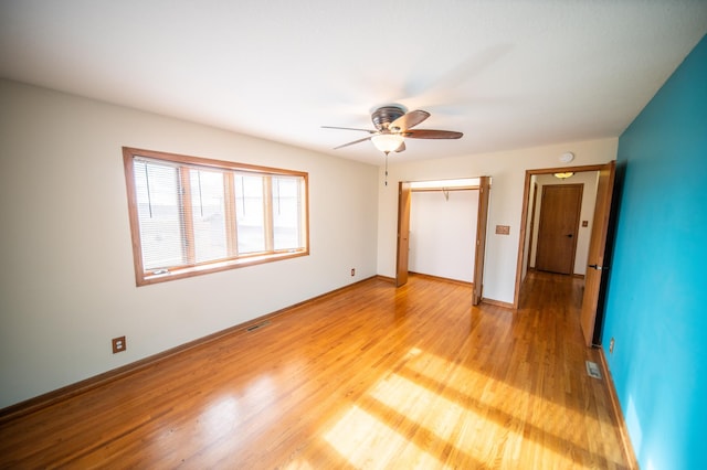 unfurnished bedroom featuring a closet, light hardwood / wood-style flooring, and ceiling fan