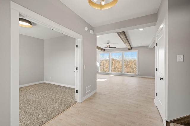 corridor with light hardwood / wood-style floors and beamed ceiling