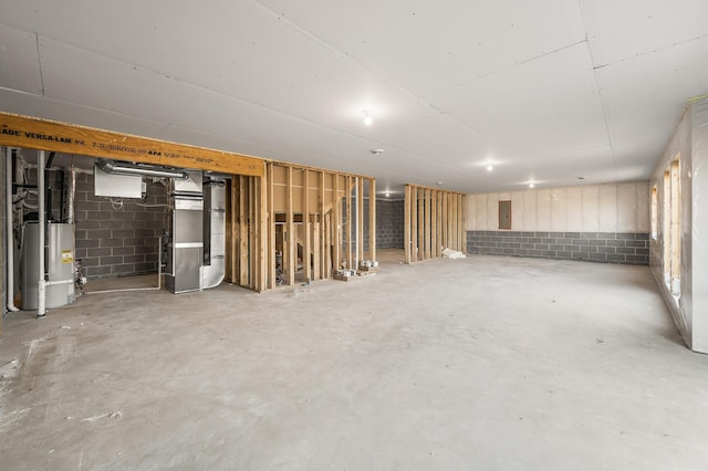 basement with heating unit, electric panel, and water heater