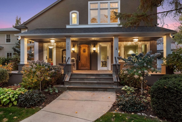 exterior entry at dusk featuring covered porch