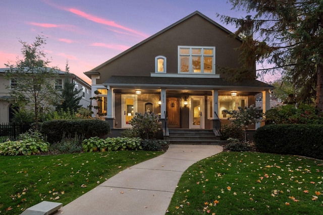 view of front of home with a lawn and a porch