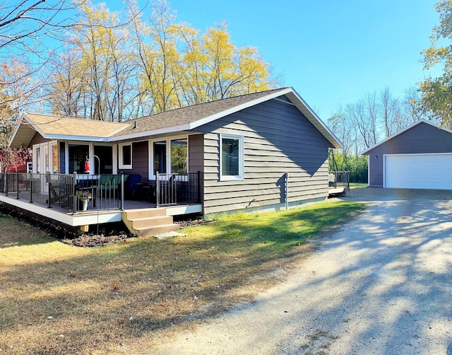 view of front of property featuring an outbuilding, a porch, a garage, and a front yard