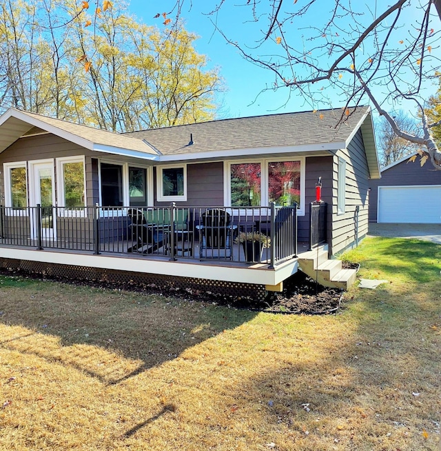 rear view of house featuring an outbuilding, a yard, and a garage