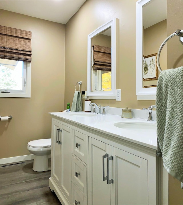 bathroom with hardwood / wood-style floors, vanity, and toilet