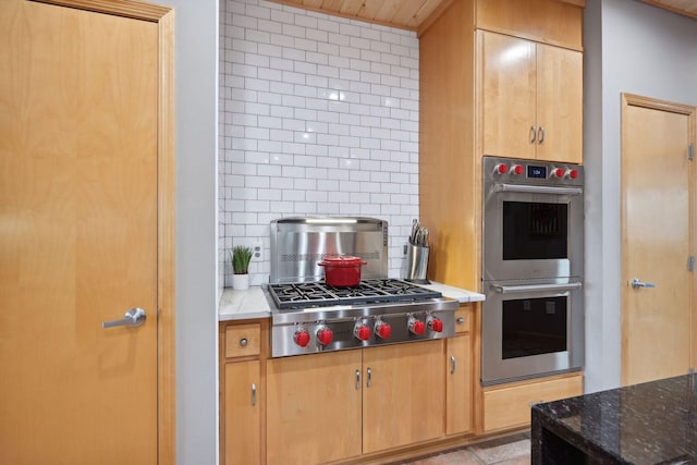 kitchen featuring decorative backsplash, appliances with stainless steel finishes, and stone counters