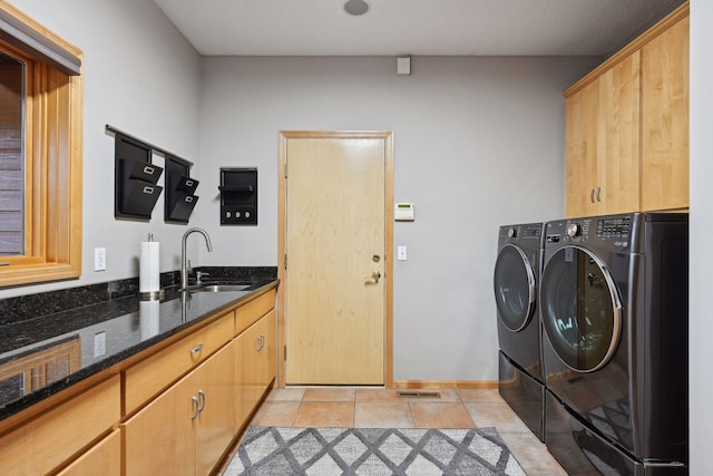 washroom with cabinets, separate washer and dryer, sink, and light tile patterned flooring