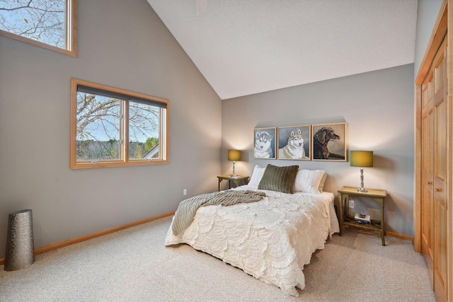 bedroom with light colored carpet, a closet, and high vaulted ceiling