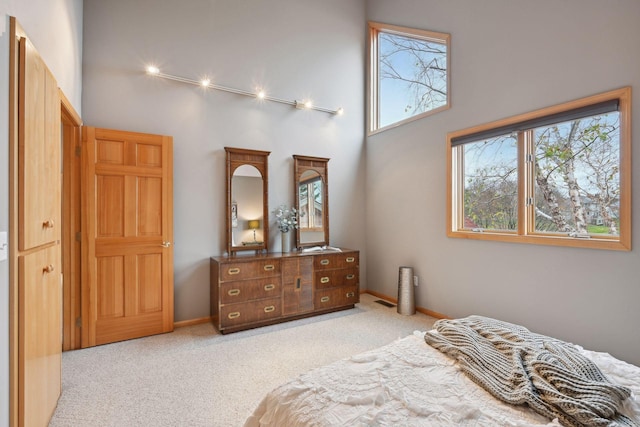 carpeted bedroom featuring a towering ceiling