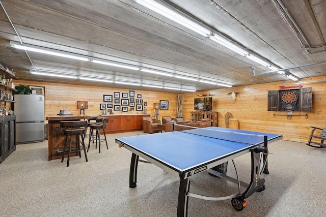 game room with wood walls, light carpet, and indoor bar