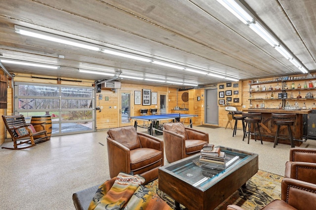 interior space with bar area, wooden walls, and an AC wall unit