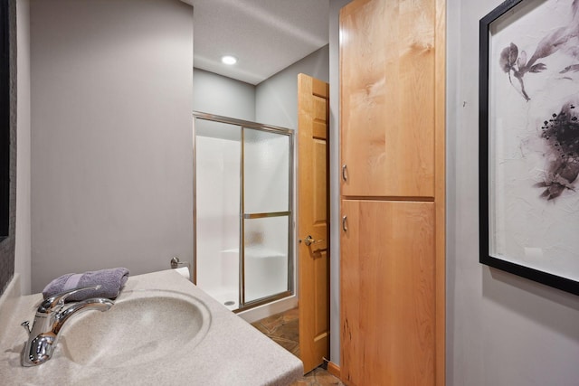 bathroom with walk in shower, sink, tile patterned floors, and a textured ceiling