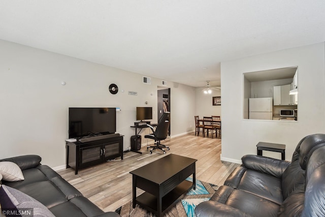 living room featuring light hardwood / wood-style floors and ceiling fan