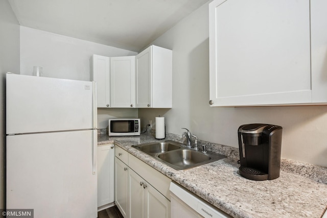 kitchen with white appliances, wood-type flooring, sink, white cabinetry, and light stone counters