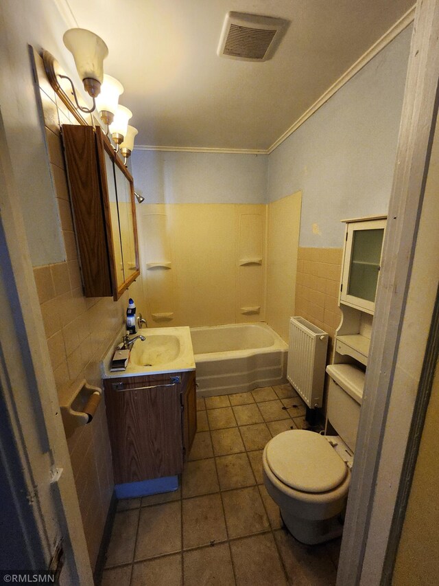 full bathroom featuring radiator heating unit, tile walls, toilet, vanity, and tile patterned floors