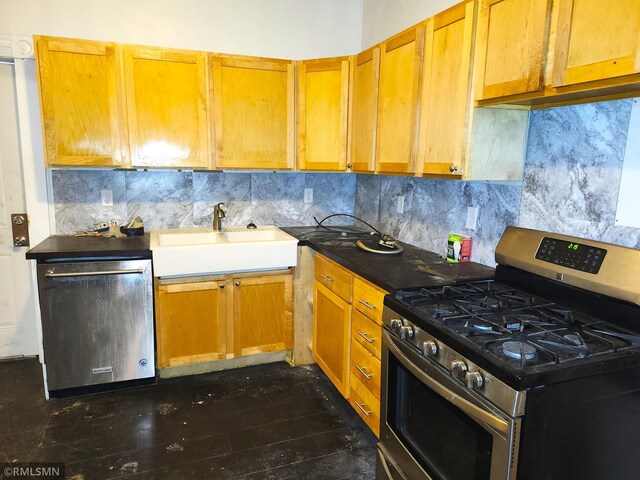 kitchen with appliances with stainless steel finishes, dark hardwood / wood-style flooring, sink, and backsplash