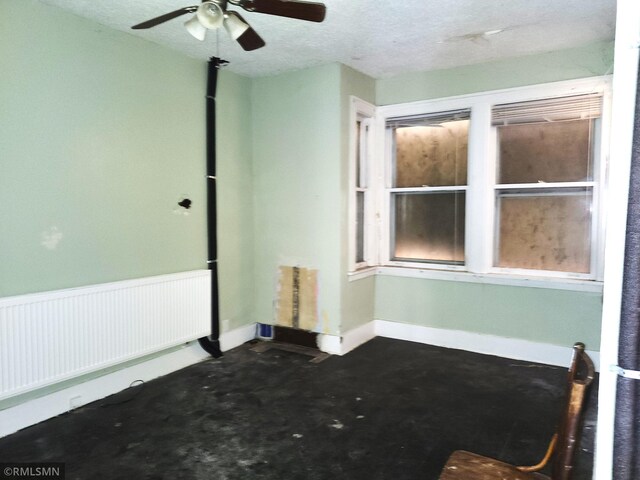 spare room featuring a textured ceiling, radiator, and ceiling fan