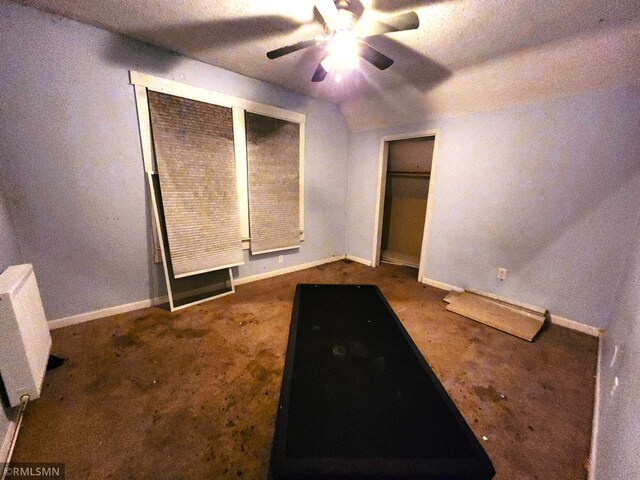 unfurnished bedroom featuring ceiling fan, carpet, and a textured ceiling