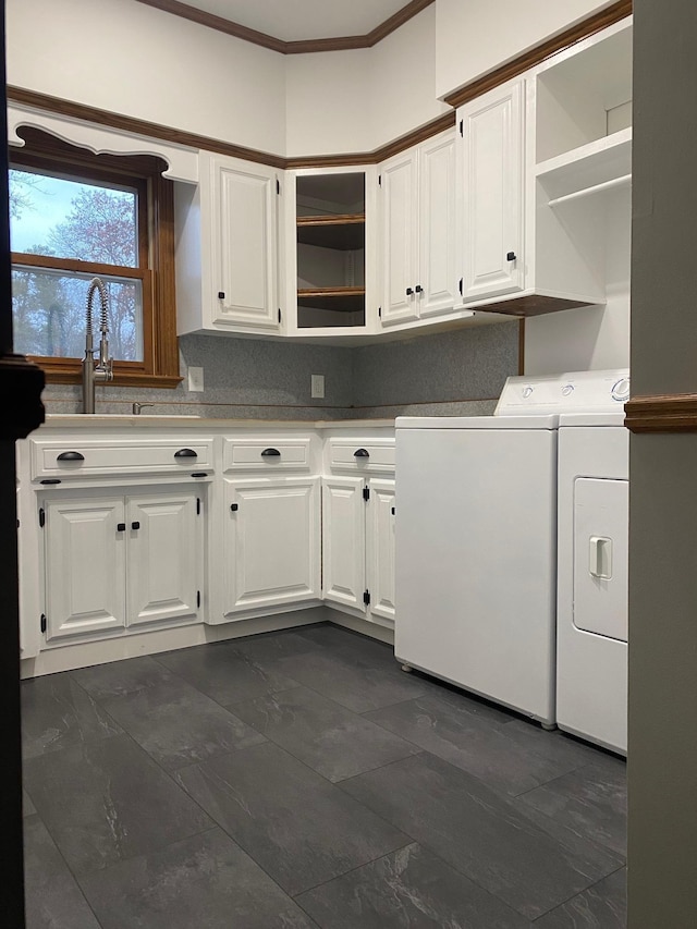 washroom with cabinets, ornamental molding, and washer and clothes dryer