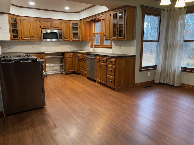 kitchen featuring sink, crown molding, stainless steel appliances, and light hardwood / wood-style floors