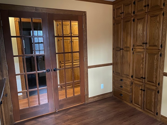 doorway with french doors, dark wood-type flooring, and crown molding