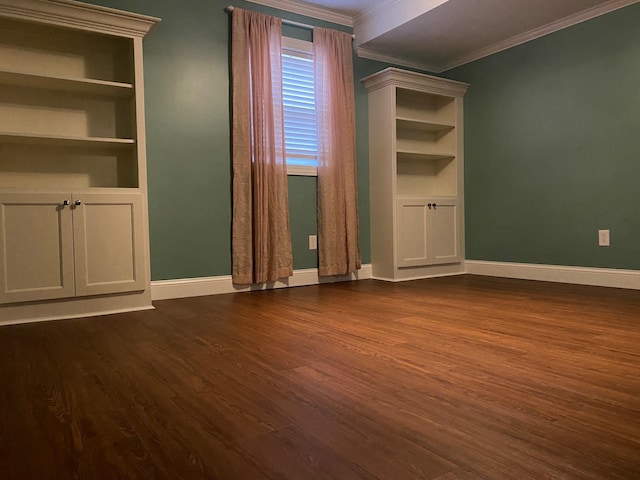 empty room with crown molding, dark hardwood / wood-style floors, and built in shelves