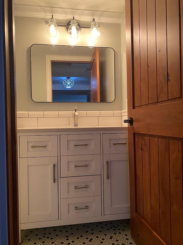 bathroom with vanity, crown molding, and tile patterned flooring