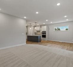 unfurnished living room featuring light carpet