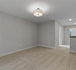 unfurnished room featuring light carpet