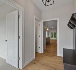 hallway featuring light wood-type flooring and an inviting chandelier