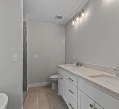 bathroom featuring tile patterned flooring, vanity, and toilet