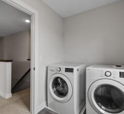 clothes washing area with separate washer and dryer