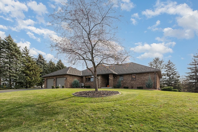 view of front of home featuring driveway, a front yard, brick siding, and an attached garage