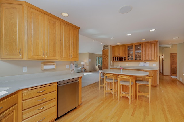 kitchen featuring light countertops, light wood-style floors, and stainless steel dishwasher