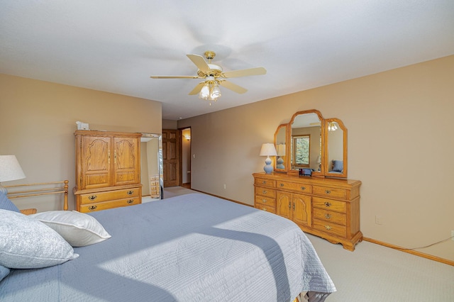 bedroom featuring baseboards, light colored carpet, and a ceiling fan