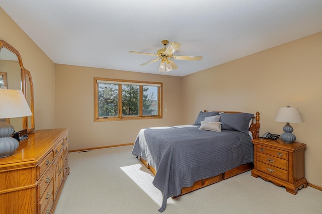 bedroom with ceiling fan, baseboards, and light carpet